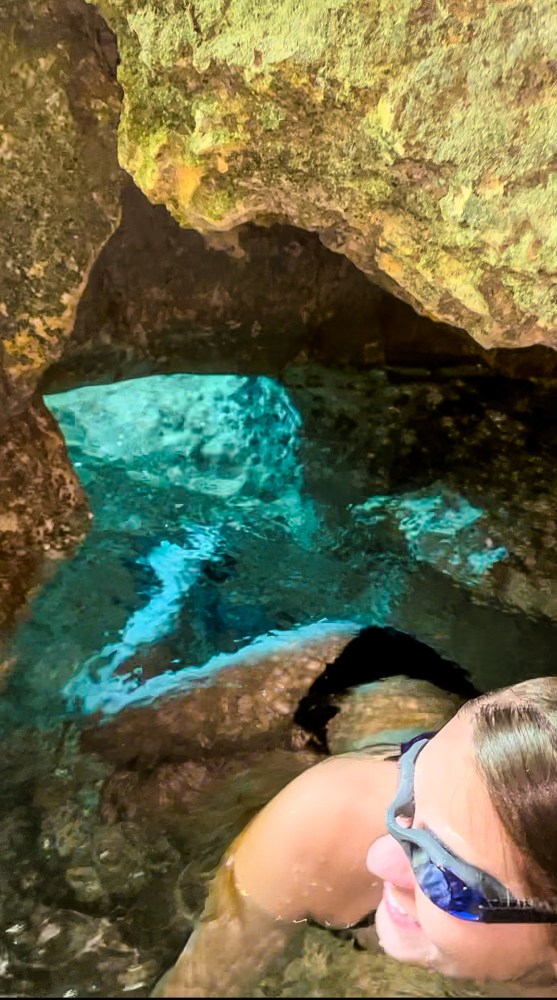 a person sitting on a rock in a pool of water