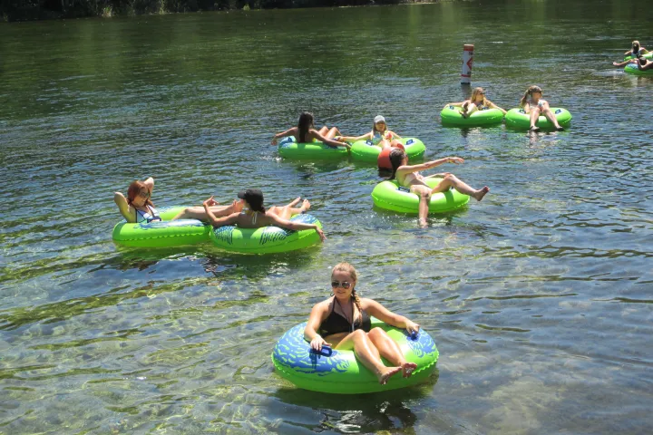 a group of people riding on the back of a boat in the water